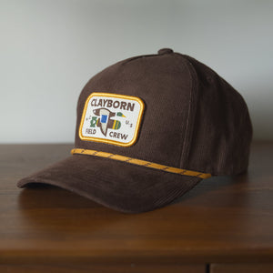 brown corduroy hat with rope and a patch of a mallard duck carrying a bomb