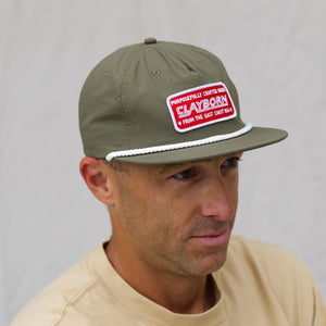 Green Surf Cap  with red and white Clayborn vibe style patch Surf Cap on Model Looking Off to the side. 